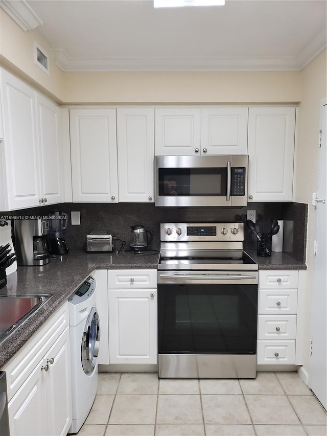 kitchen with washer / clothes dryer, white cabinets, ornamental molding, and appliances with stainless steel finishes