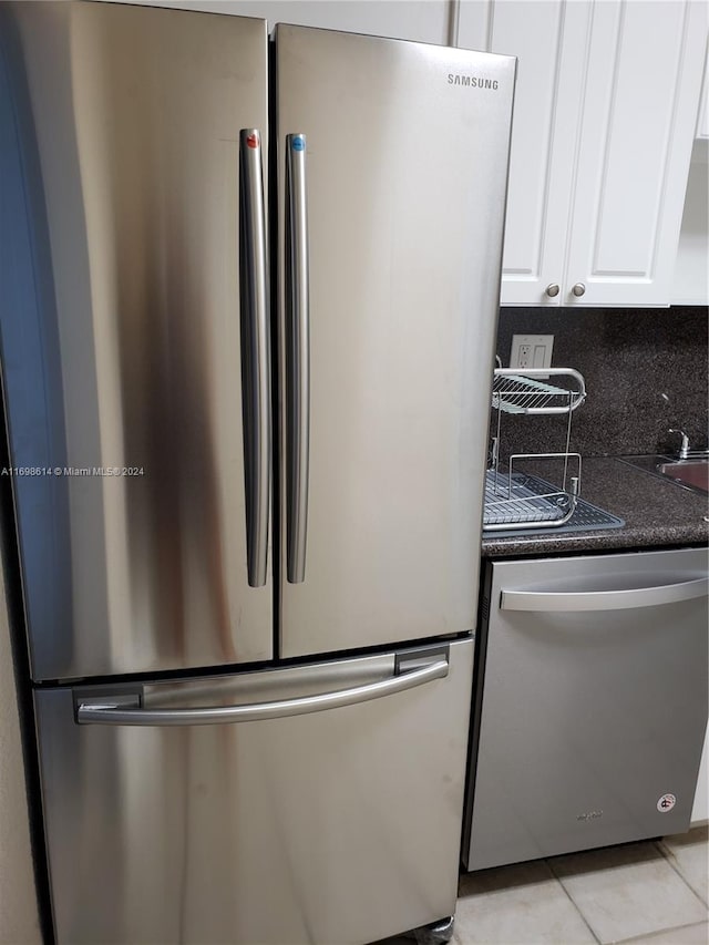 room details with white cabinets, backsplash, and appliances with stainless steel finishes