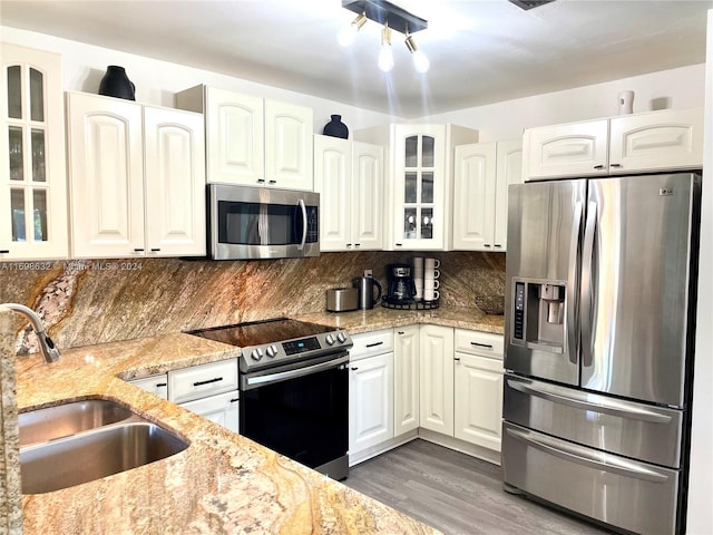 kitchen with light stone countertops, sink, dark hardwood / wood-style floors, white cabinets, and appliances with stainless steel finishes