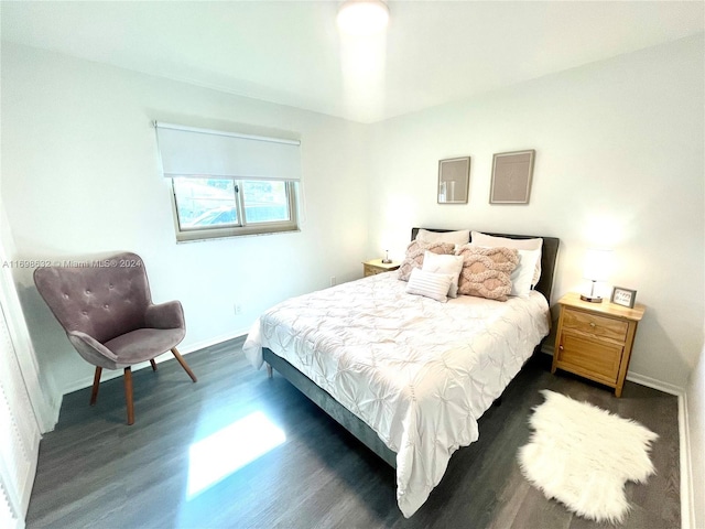 bedroom with dark hardwood / wood-style flooring