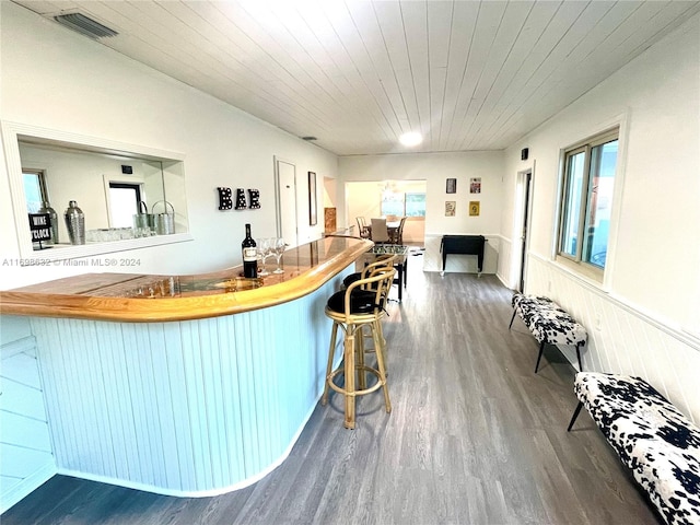 interior space featuring dark hardwood / wood-style floors, a breakfast bar area, and wood ceiling