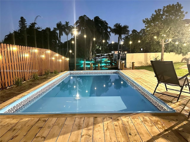 pool at dusk with a wooden deck