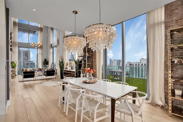 dining space with floor to ceiling windows, light hardwood / wood-style flooring, and a chandelier