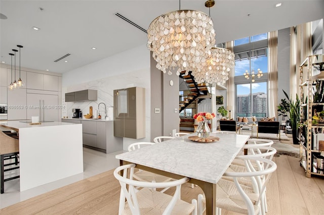 dining area featuring sink, light hardwood / wood-style floors, and a notable chandelier