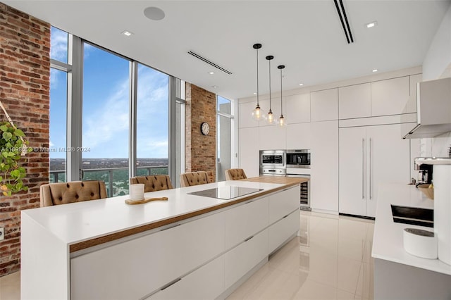 kitchen with black electric cooktop, decorative light fixtures, white cabinetry, paneled built in fridge, and a kitchen island