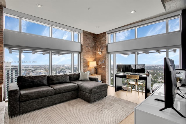 living room with light hardwood / wood-style flooring, a healthy amount of sunlight, and a high ceiling