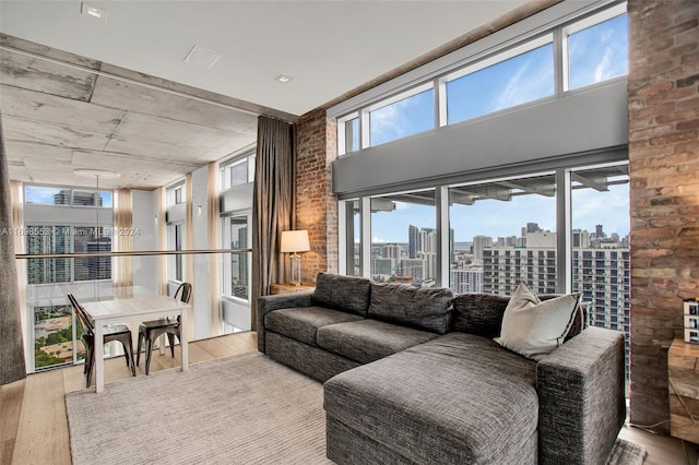 living room featuring a healthy amount of sunlight, light hardwood / wood-style floors, and a high ceiling