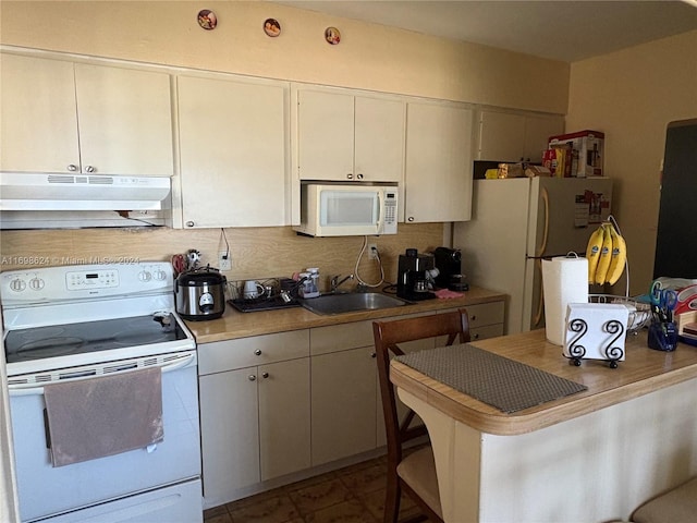 kitchen with white appliances, ventilation hood, white cabinets, sink, and a breakfast bar area