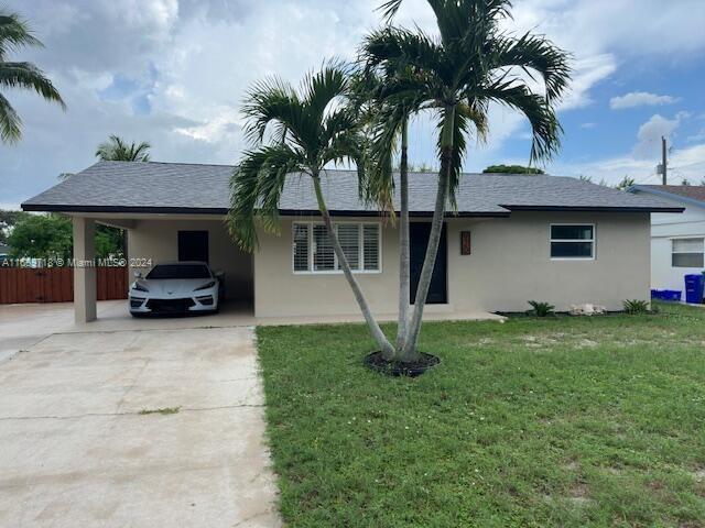 single story home with a front lawn and a carport