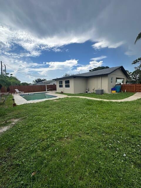 view of yard with a fenced in pool and central AC unit