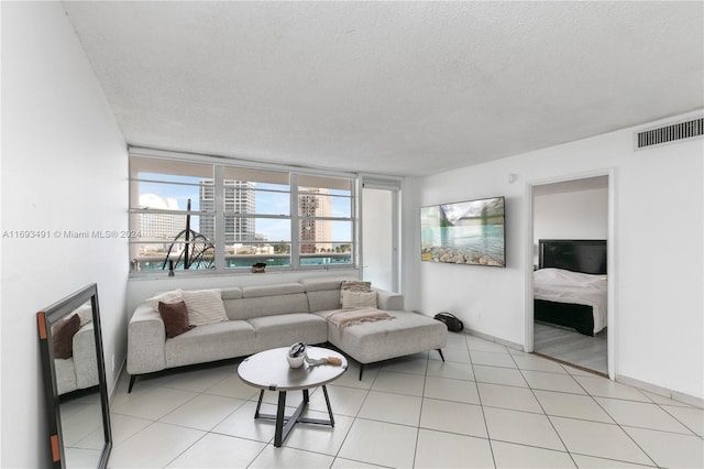 tiled living room featuring a textured ceiling