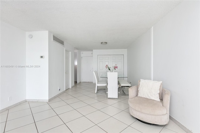 dining space featuring light tile patterned floors and a textured ceiling