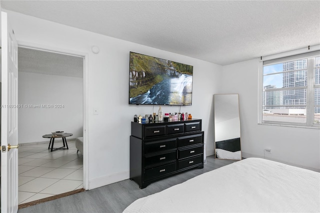 bedroom featuring a textured ceiling and hardwood / wood-style flooring