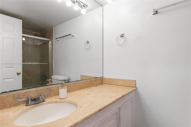 bathroom with vanity, toilet, and walk in shower