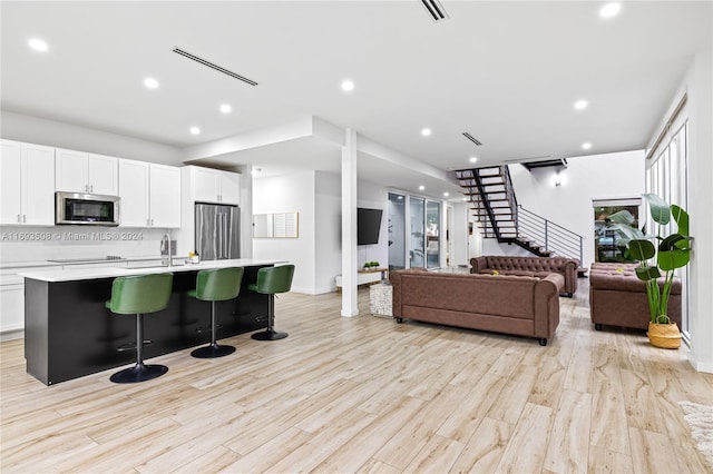 living room with light hardwood / wood-style floors and sink