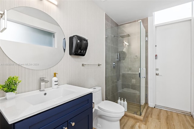 bathroom featuring vanity, toilet, wood-type flooring, and walk in shower