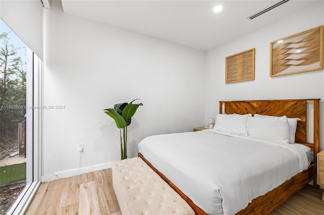 bedroom with access to outside and light wood-type flooring