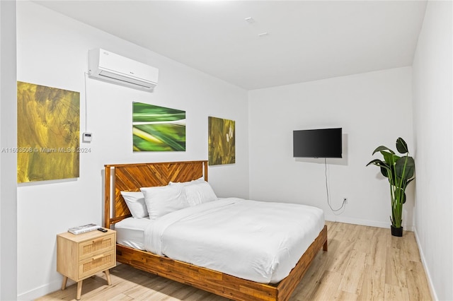 bedroom featuring light wood-type flooring and a wall mounted AC