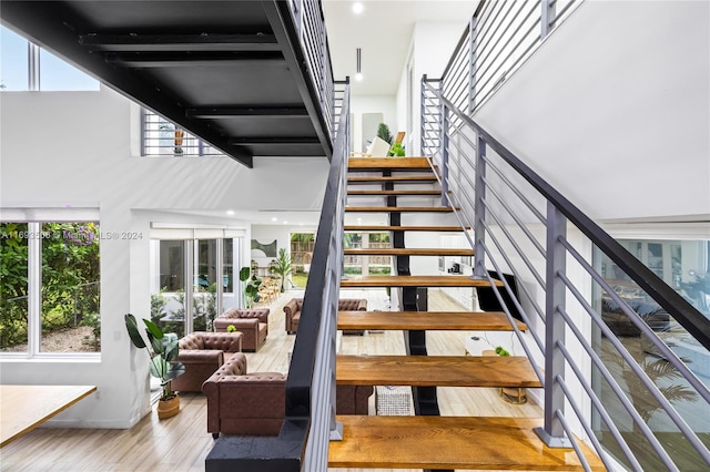 staircase featuring hardwood / wood-style floors and a towering ceiling