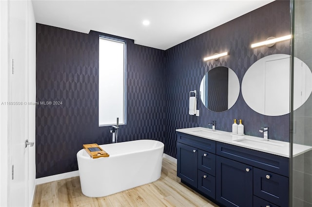 bathroom featuring hardwood / wood-style floors, vanity, and a tub to relax in