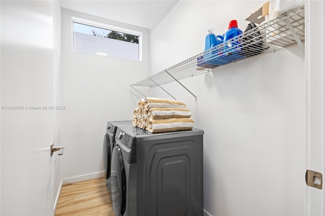 laundry room with hardwood / wood-style flooring and washing machine and dryer