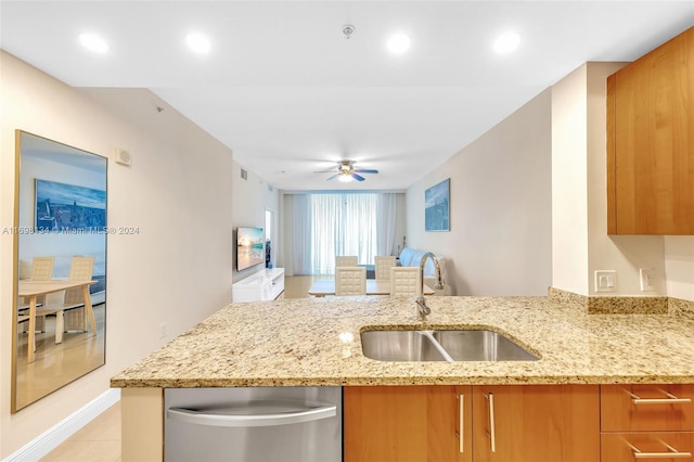 kitchen with ceiling fan, sink, and light stone counters