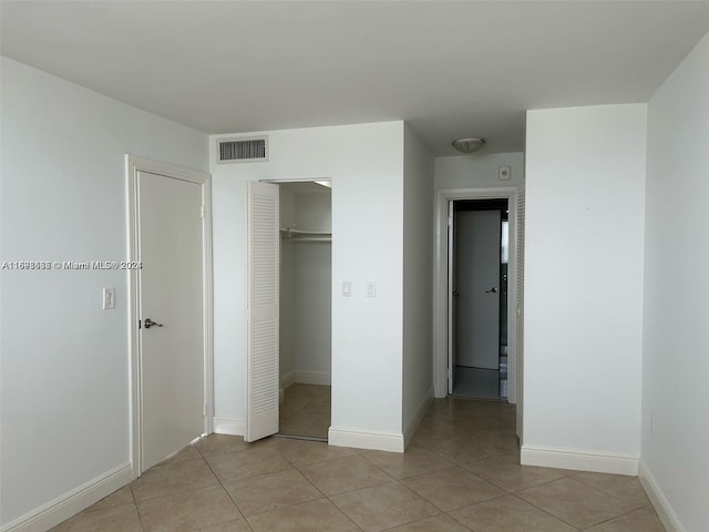 unfurnished bedroom featuring a closet and light tile patterned floors