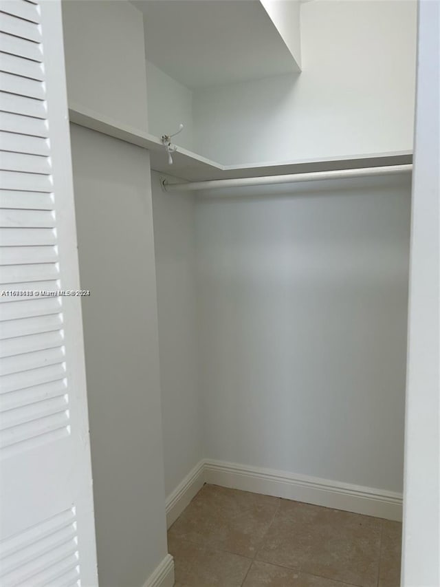 walk in closet with tile patterned floors