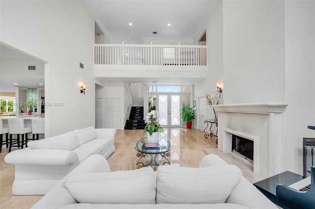 living room featuring light wood-type flooring, a towering ceiling, and plenty of natural light