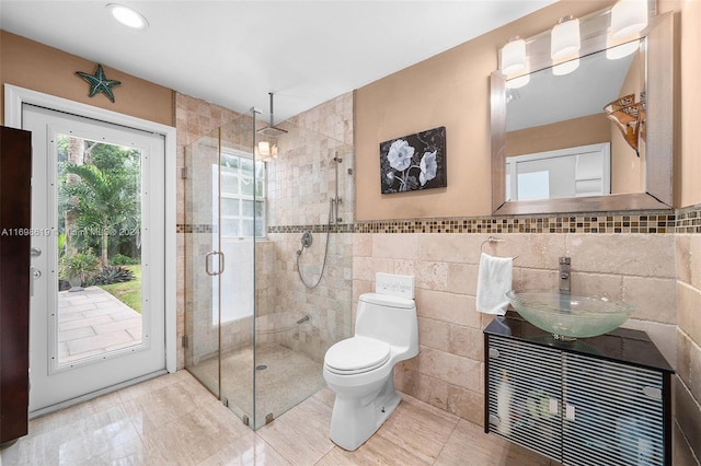 bathroom with vanity, toilet, tile walls, and walk in shower