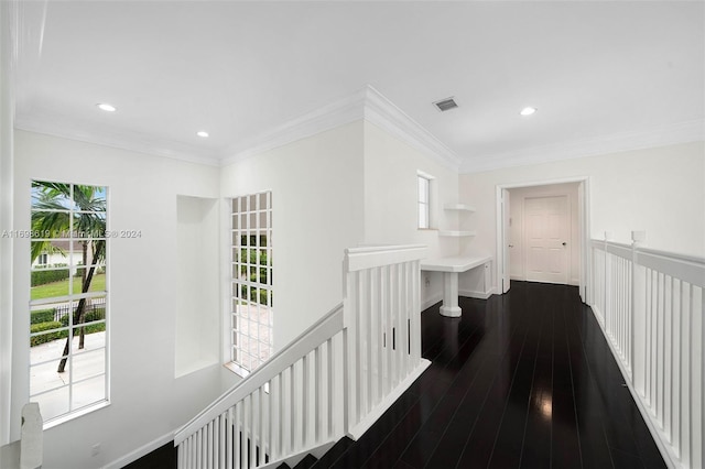 hallway with dark hardwood / wood-style flooring, plenty of natural light, and crown molding