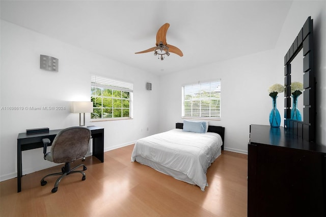 bedroom with hardwood / wood-style floors, multiple windows, and ceiling fan