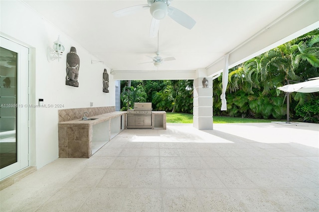 view of patio with ceiling fan, area for grilling, and sink