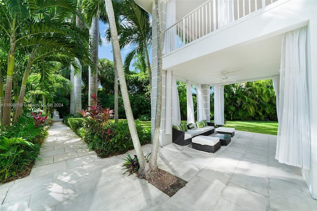 view of patio with ceiling fan and a balcony