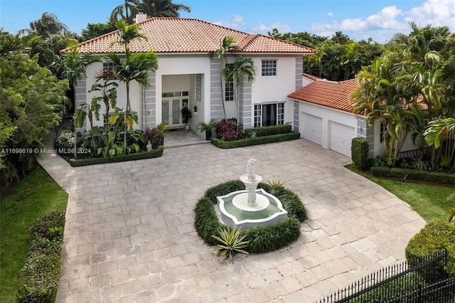 mediterranean / spanish home with french doors and a garage