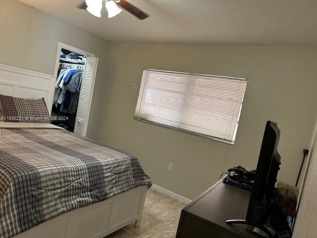 tiled bedroom featuring ceiling fan and a closet