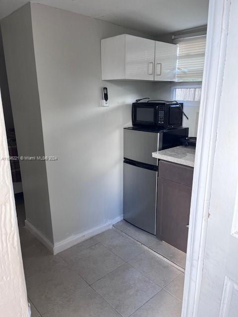 kitchen with white cabinets and light tile patterned floors