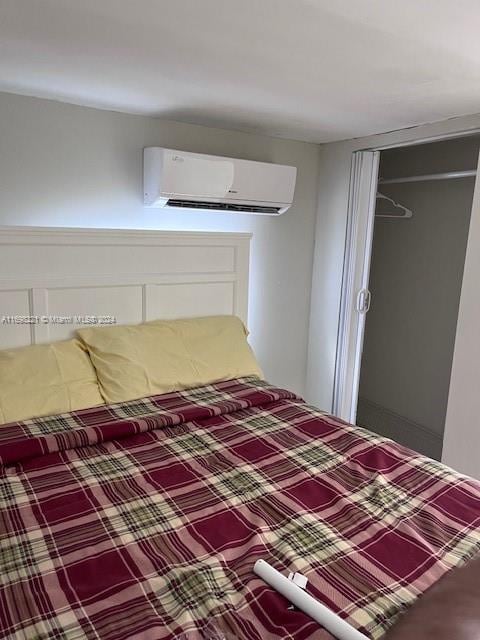 unfurnished bedroom with a closet and a wall mounted air conditioner