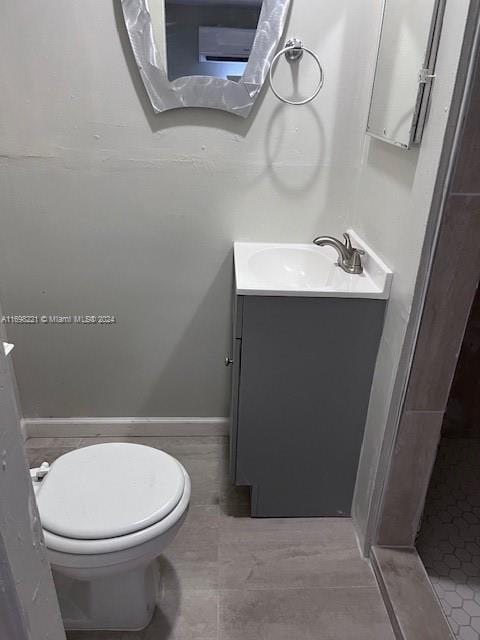 bathroom featuring tile patterned floors, vanity, toilet, and a shower