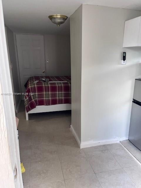 tiled bedroom with stainless steel fridge