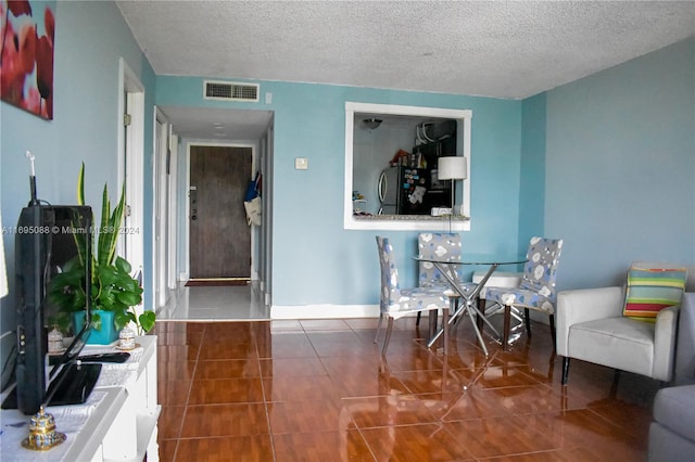 dining area featuring a textured ceiling and dark tile patterned floors