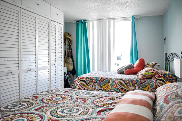 bedroom with a textured ceiling and a closet