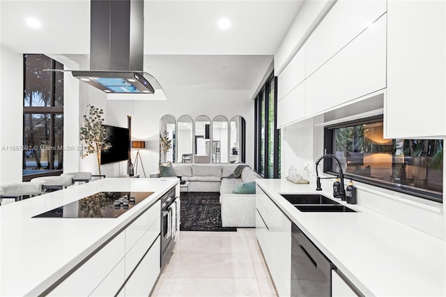 kitchen with black appliances, white cabinets, sink, light tile patterned flooring, and island exhaust hood