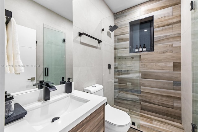 bathroom with vanity, toilet, and a shower with shower door