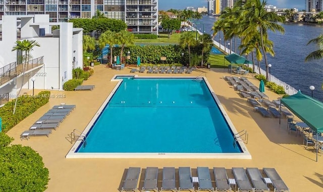 view of pool with a patio area and a water view