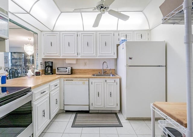 kitchen featuring white cabinetry, sink, backsplash, white appliances, and light tile patterned floors