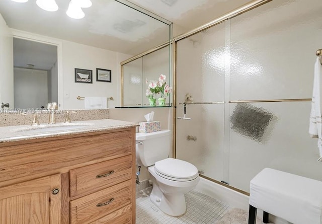 bathroom featuring toilet, tile patterned flooring, vanity, and walk in shower