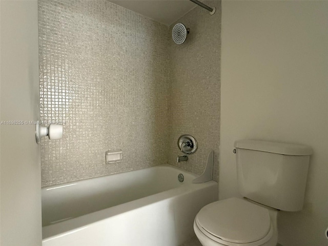 bathroom with toilet and tiled shower / bath