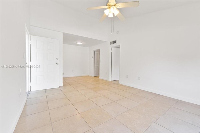 tiled spare room with ceiling fan and high vaulted ceiling