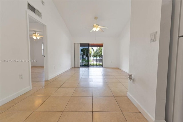 tiled empty room featuring vaulted ceiling and ceiling fan